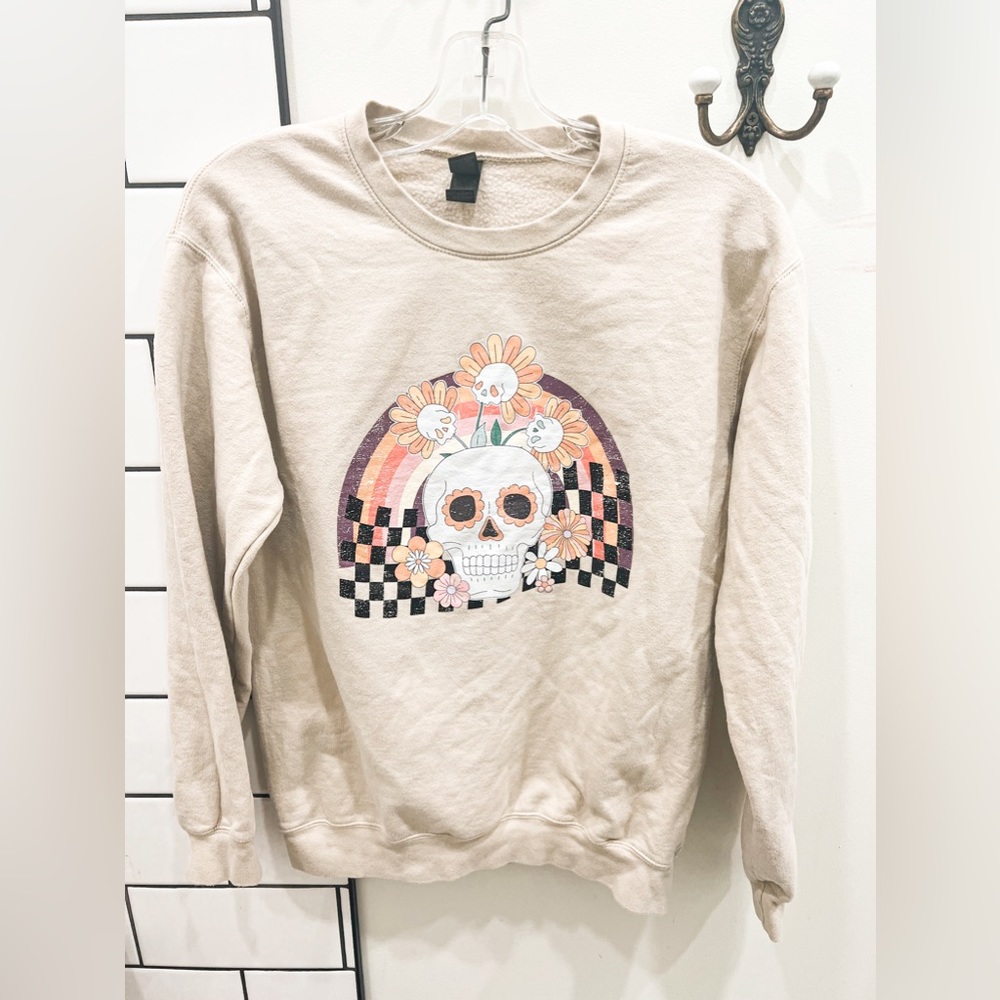 Size small women’s beige crewneck with skull and checker design.